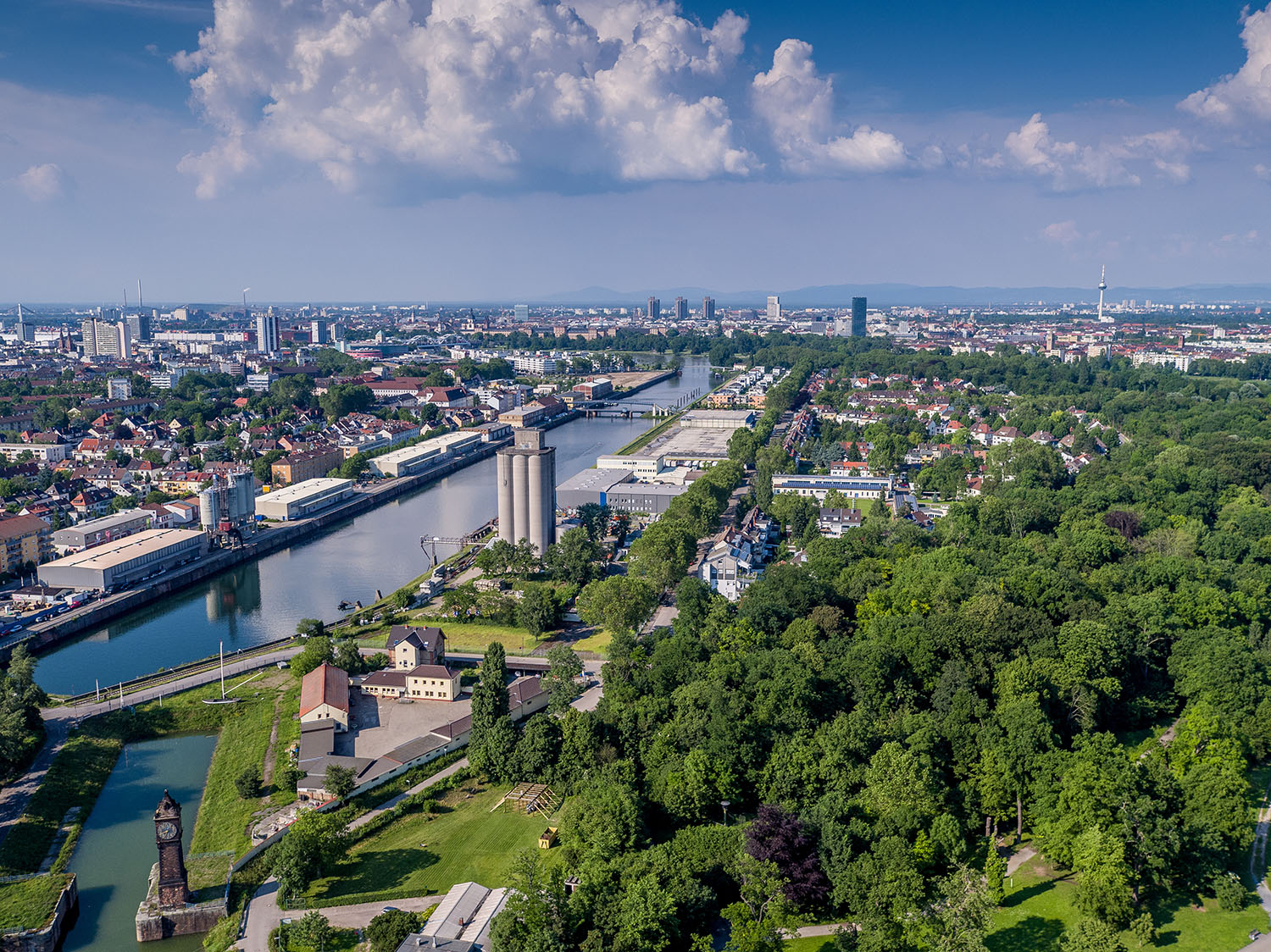 Luftaufnahme von Ludwigshafen am Rhein mit dem Stadthafen, dem Rhein-Kanal und der Skyline von Mannheim im Hintergrund.