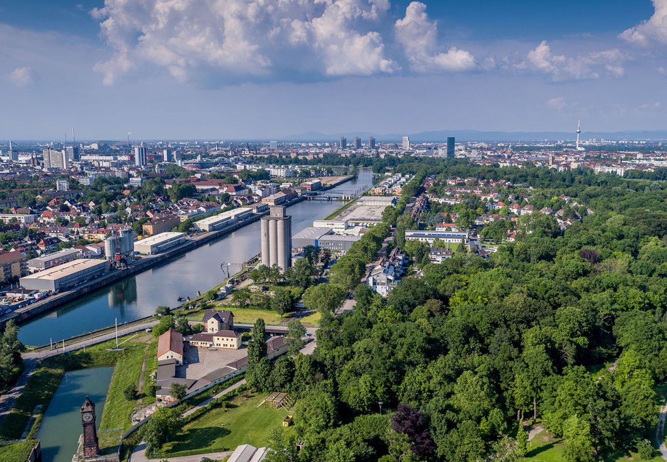 Luftaufnahme von Ludwigshafen am Rhein mit dem Stadthafen, dem Rhein-Kanal und der Skyline von Mannheim im Hintergrund.