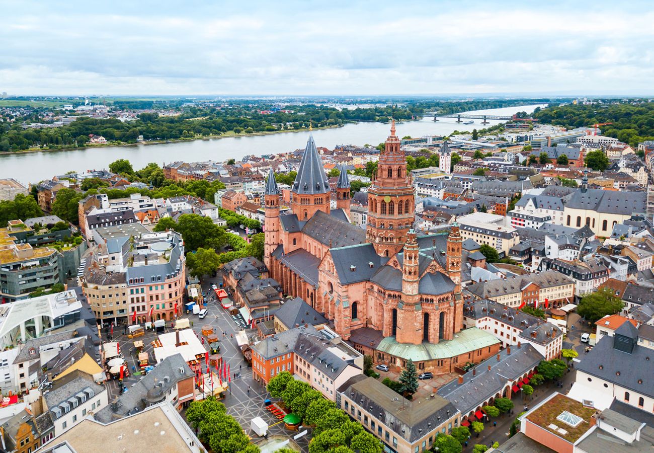 Luftaufnahme der Mainzer Altstadt mit dem imposanten Mainzer Dom Sankt Martin im Mittelpunkt, umgeben von der historischen Innenstadt und dem Rhein im Hintergrund.