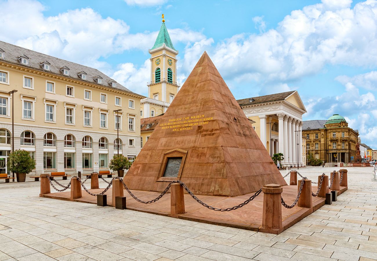 Die Karlsruher Pyramide auf dem Marktplatz, das Wahrzeichen der Stadt als Grabmal von Stadtgründer Markgraf Carl Wilhelm, mit dem Rathausturm und dem Stadttheater im Hintergrund.